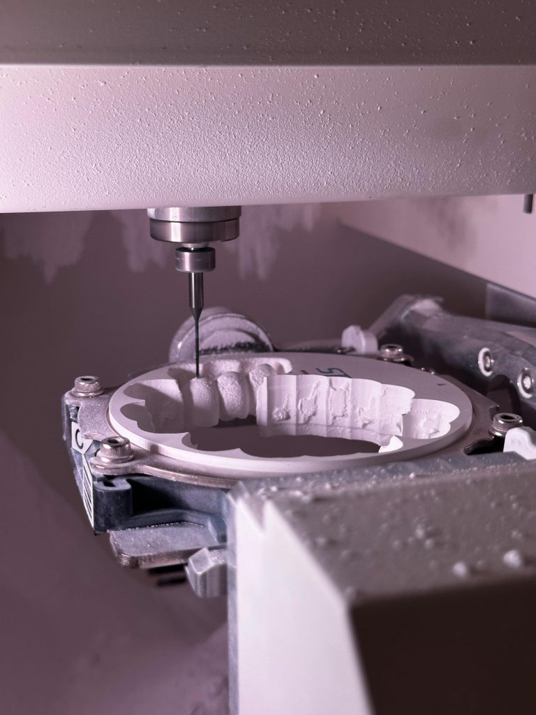 Detailed view of CNC grinding machine shaping ceramic material with precision tool.